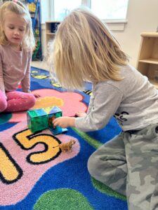 Two young children playing on a mat.