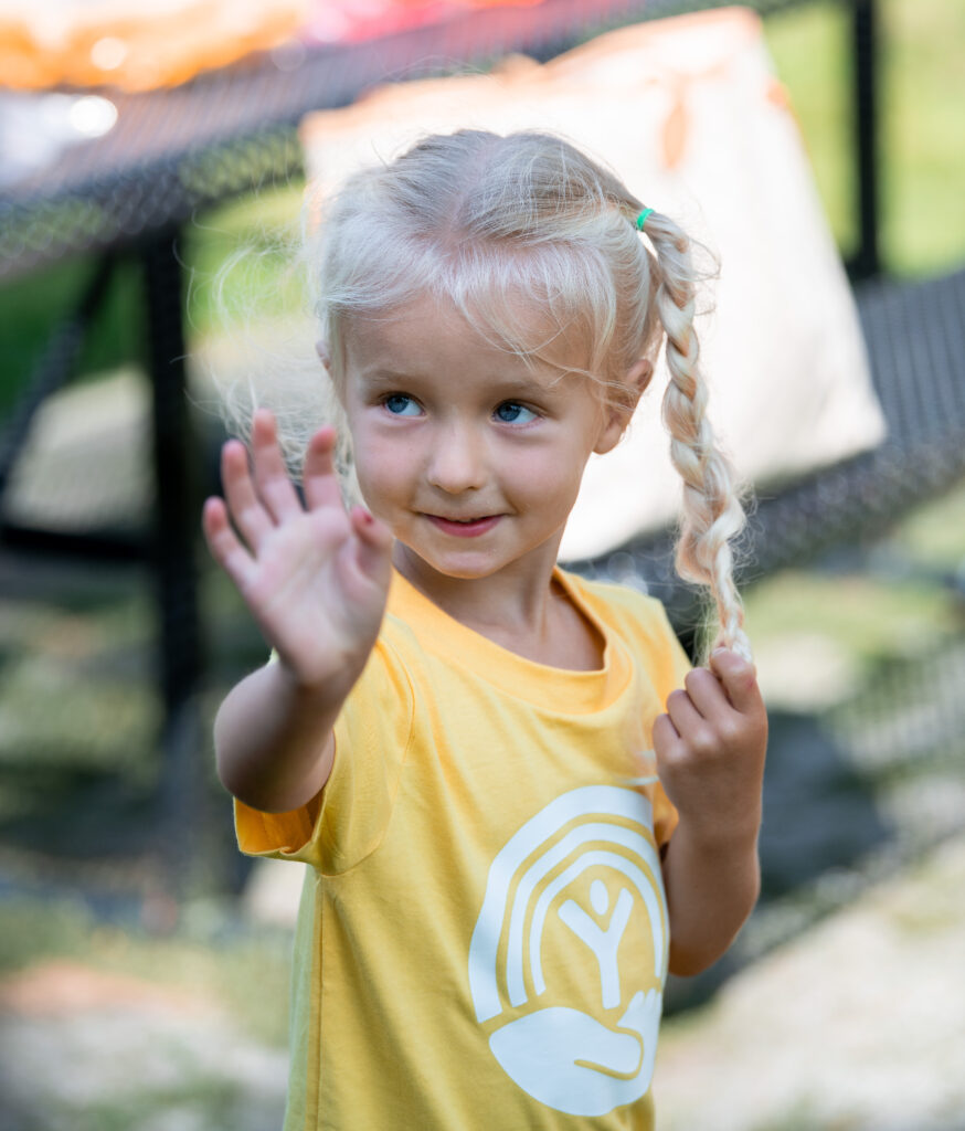 Blonde little girl waving